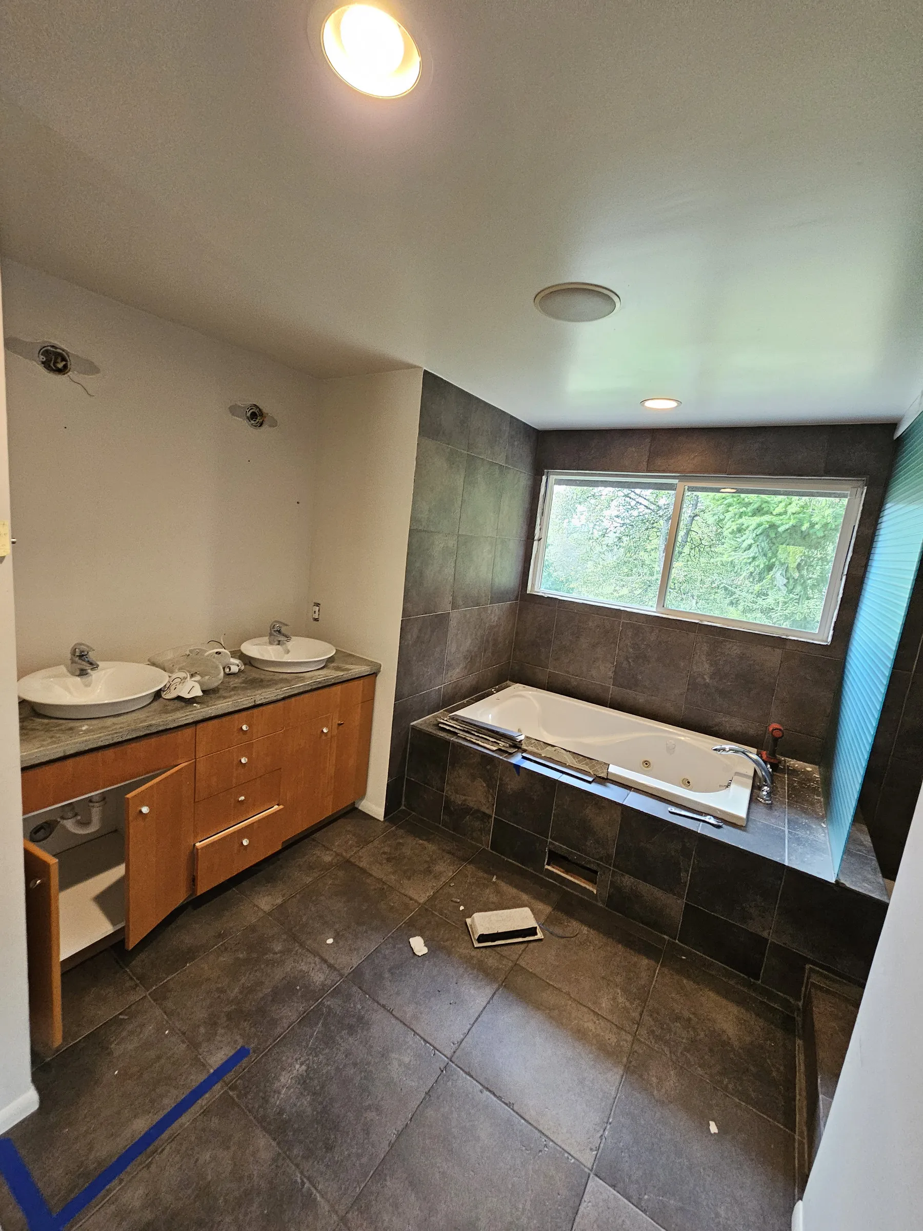 Before — oak vanity and jetted tub to a lit mirror and freestanding tub — Juanita, Kirkland