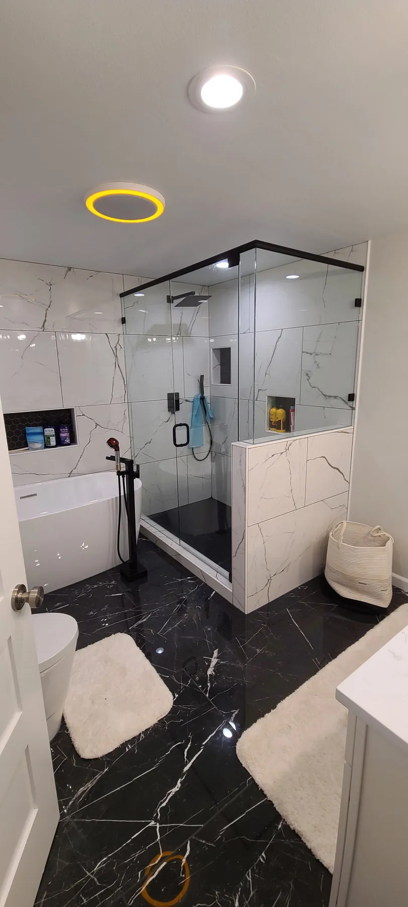 After — tiling going up, then glass shower and black marble floor — Renton