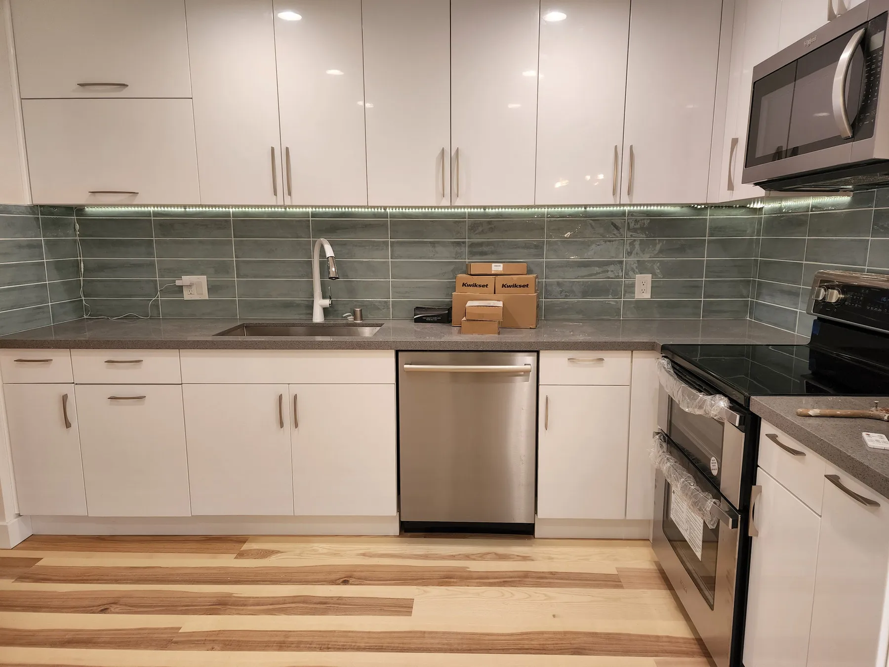 A tiled backsplash running up the wall behind a range in a finished kitchen