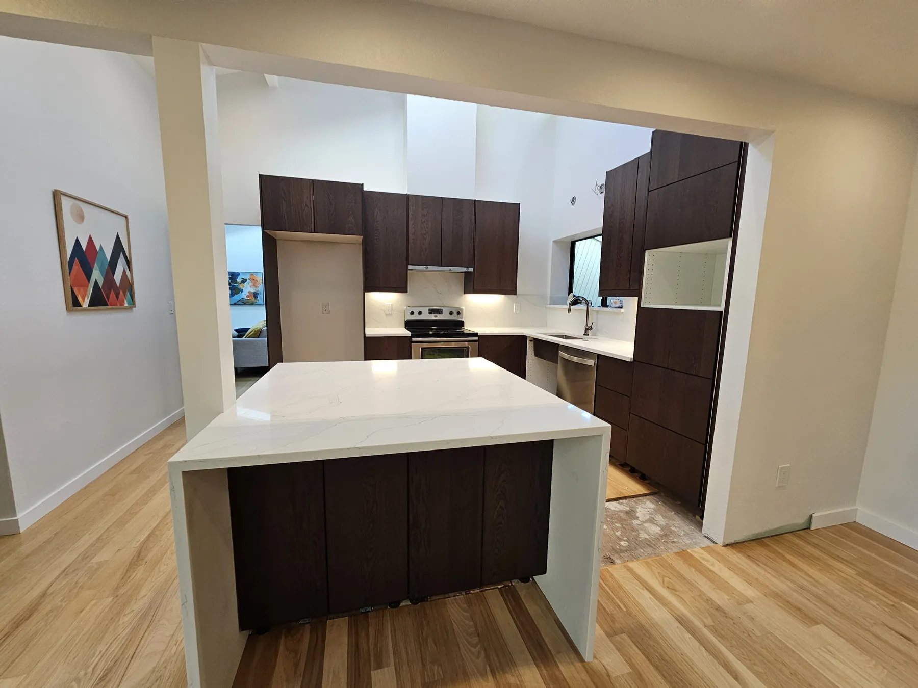 A quartz countertop and waterfall island edge in a finished kitchen