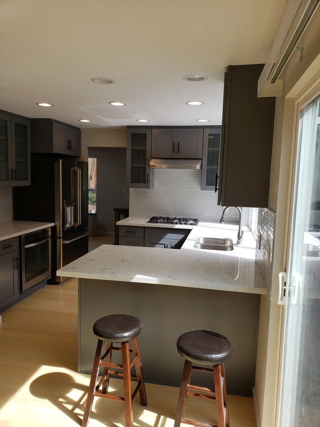 Wide-plank wood flooring running through a finished kitchen and dining area