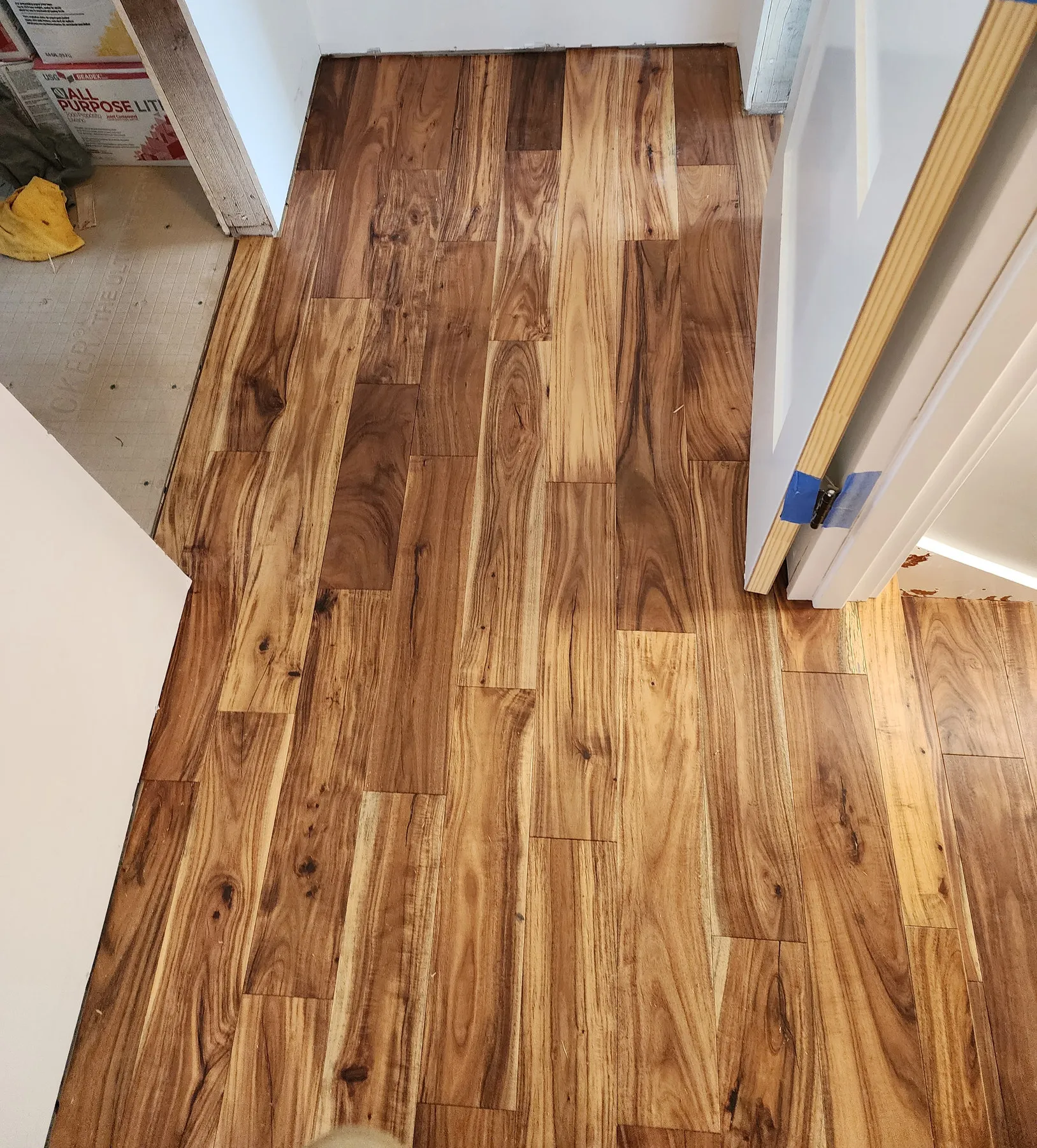 Acacia hardwood flooring laid through a hallway on a Renton job