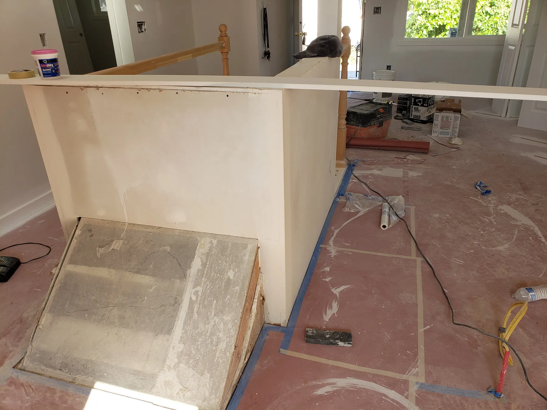 Before — half-wall and bare subfloor to a white kitchen with an island — Ballard, Seattle
